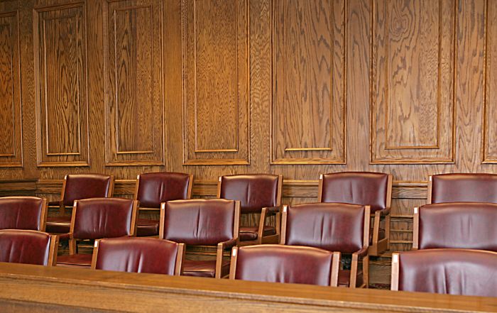 Empty courtroom chairs arranged neatly, symbolizing legal proceedings and awaiting trial participants.