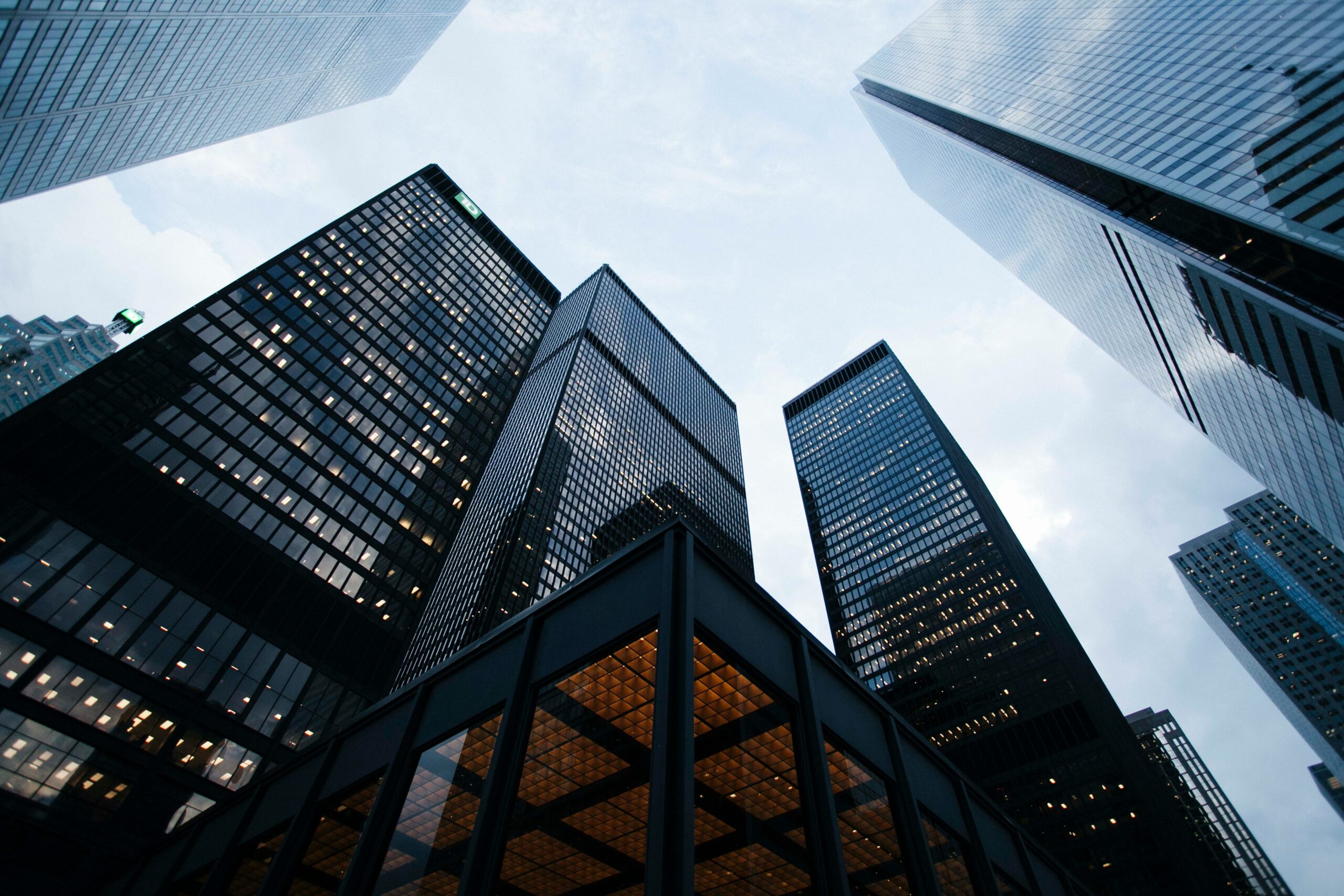 View looking up at downtown skyscrapers from street level, symbolizing corporate power, global business, and legal oversight.